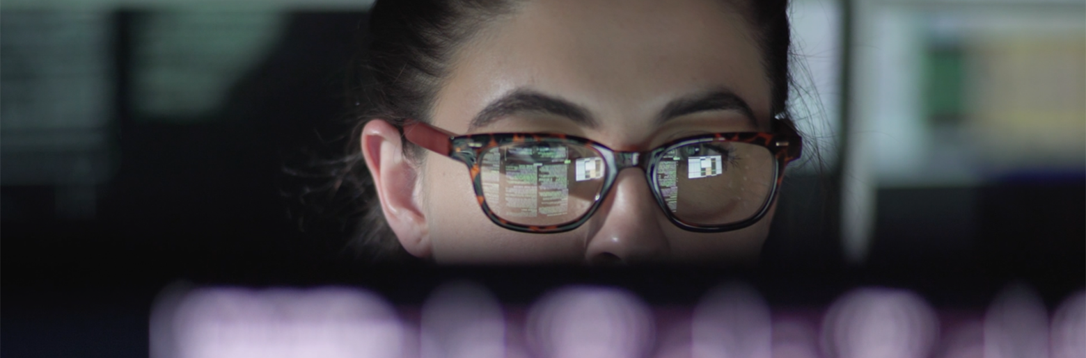 Frau mit Brille vor einem Laptop