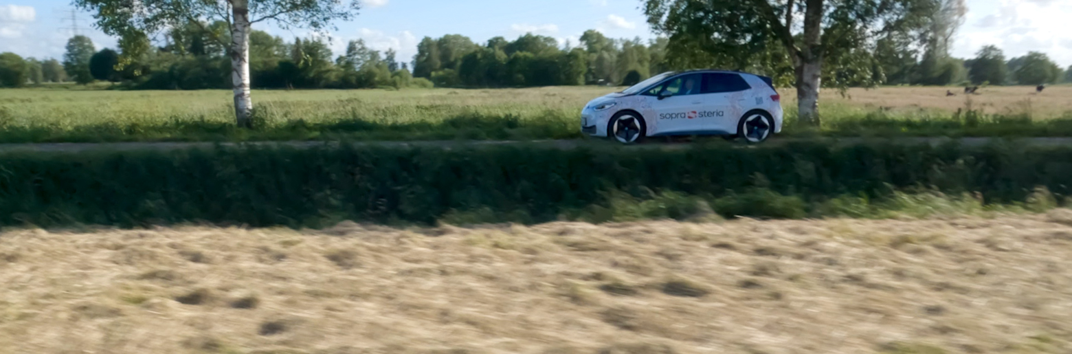 E-Auto mit Sopra Steria Logo auf Landstraße
